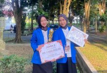 Dua mahasiswa Farmasi UMP memegang piala dan sertifikat Juara 2 Poster Infografis di Pharmacito 2026.