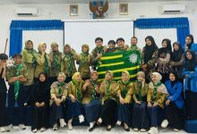 Foto bersama pengurus terpilih GK HW STIE Muhammadiyah Cilacap memegang bendera Hizbul Wathan di aula kampus usai musyawarah kafilah, mengusung misi baru konservasi pesisir.