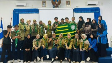 Foto bersama pengurus terpilih GK HW STIE Muhammadiyah Cilacap memegang bendera Hizbul Wathan di aula kampus usai musyawarah kafilah, mengusung misi baru konservasi pesisir.
