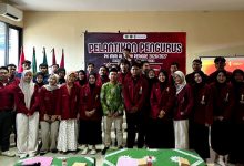 Sekelompok mahasiswa pengurus IMM berpose untuk foto bersama dengan pejabat universitas setelah pelantikan.