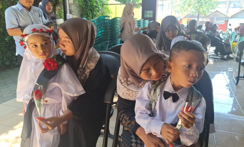 Momen haru saat prosesi Pelepasan Siswa TK ABA Pesindon Pekalongan di mana anak-anak memeluk ibu mereka sambil membawa setangkai bunga mawar.