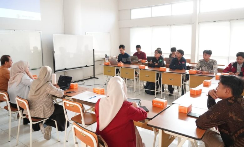 Sekelompok orang duduk di ruang kelas mendengarkan presentasi