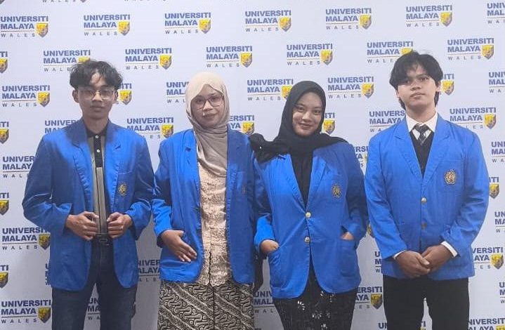Empat mahasiswa FEB UMP mengenakan almamater biru berfoto bersama setelah memenangkan kompetisi inovasi bisnis digital mahasiswa di Malaysia.