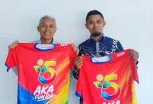Rektor UMS Prof. Dr. Harun Joko Prayitno, M.Hum. (kiri) bersama perwakilan panitia menunjukkan jersey resmi AKA Fun Run 2026 berwarna merah kombinasi pelangi dengan logo angka 5.