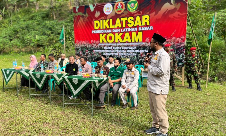 Suasana upacara pembukaan Diklatsar KOKAM Pekalongan 2026 di Lapangan Desa Rogoselo Doro dengan latar belakang spanduk besar bertuliskan Diklatsar KOKAM Marda Surya Cempaluk dan deretan tamu undangan di meja VIP.