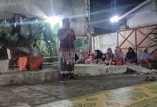 Ustaz Dwi Jatmiko berceramah menggunakan mikrofon di panggung terbuka Teras Beramal Kerten Solo pada malam hari dihadiri jamaah ibu-ibu dan anak-anak yang duduk lesehan dalam Pengajian Arloji.