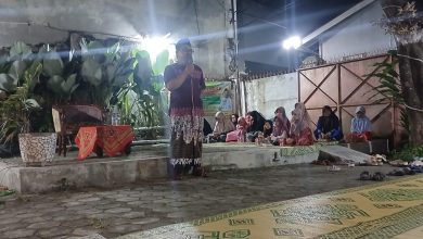 Ustaz Dwi Jatmiko berceramah menggunakan mikrofon di panggung terbuka Teras Beramal Kerten Solo pada malam hari dihadiri jamaah ibu-ibu dan anak-anak yang duduk lesehan dalam Pengajian Arloji.