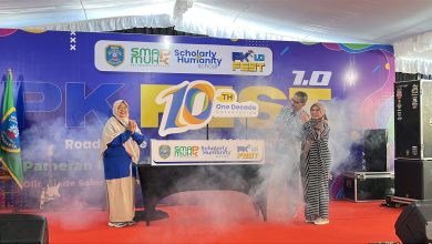 Tiga orang guru dan pimpinan sekolah berdiri bertepuk tangan di atas panggung dengan efek asap dalam acara perayaan satu dekade SMA Muhammadiyah PK Kottabarat Surakarta.