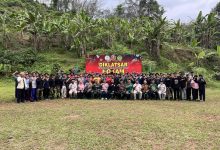 Jajaran instruktur, tamu undangan, dan puluhan peserta Diklatsar KOKAM Kabupaten Pekalongan berfoto bersama mengepalkan tangan di depan banner kegiatan di Lapangan Rogoselo Doro.