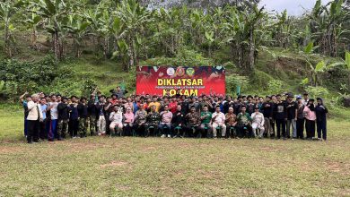 Jajaran instruktur, tamu undangan, dan puluhan peserta Diklatsar KOKAM Kabupaten Pekalongan berfoto bersama mengepalkan tangan di depan banner kegiatan di Lapangan Rogoselo Doro.