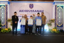 Tiga murid berprestasi didampingi guru dan kepala sekolah berdiri di atas panggung sambil memegang piagam penghargaan besar dalam acara Akhirussanah SD Muhammadiyah PK Kottabarat Solo.
