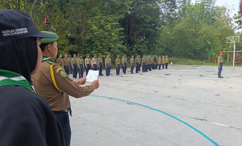 Instruktur dari Kafilah Penuntun Moh. Djazman UMS membacakan draf instruksi di depan barisan puluhan peserta upacara Diklat DSD Hizbul Wathan Kwarda Boyolali di lapangan terbuka.