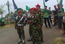 Personel Kokam Pakis Aji mengenakan seragam loreng sedang berjaga dan berkoordinasi dalam pengamanan Pengajian PDM Jepara di Sowan Kidul.