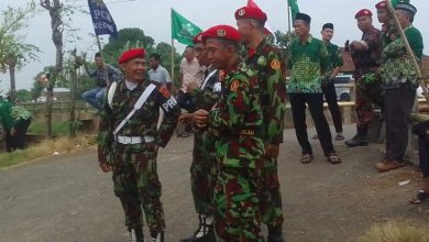 Personel Kokam Pakis Aji mengenakan seragam loreng sedang berjaga dan berkoordinasi dalam pengamanan Pengajian PDM Jepara di Sowan Kidul.