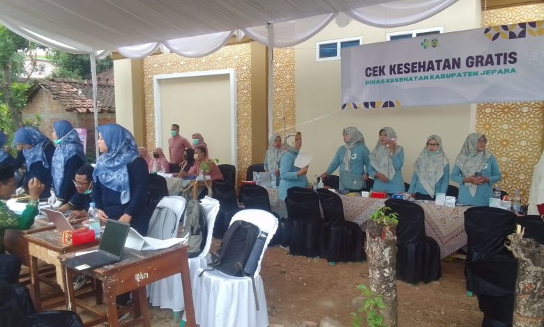 Petugas medis melayani warga dalam kegiatan cek kesehatan gratis di bawah tenda posko Dinas Kesehatan Kabupaten Jepara.