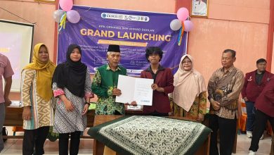 Perwakilan Pemkab Grobogan bersama perwakilan mahasiswa UNIMUS memegang dokumen kerja sama di depan banner Grand Launching PPK Ormawa IMM Ahmad Dahlan.