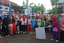Suasana pelepasan peserta jalan sehat Milad ke-109 Aisyiyah Cabang Sampang Cilacap oleh panitia menggunakan bendera start catur.