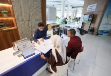 Petugas informasi melayani calon mahasiswa baru beserta orang tua di meja pendaftaran PMB UMS 2026 Gedung Induk Siti Walidah Universitas Muhammadiyah Surakarta.
