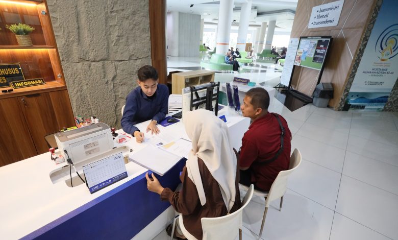 Petugas informasi melayani calon mahasiswa baru beserta orang tua di meja pendaftaran PMB UMS 2026 Gedung Induk Siti Walidah Universitas Muhammadiyah Surakarta.