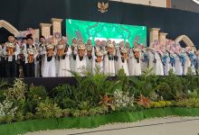 Para siswa peserta Haflah Khotmil dan Tahfidz Al-Quran SD Muhammadiyah Parakan Temanggung berdiri di atas panggung wisuda sambil membawa buket bunga.