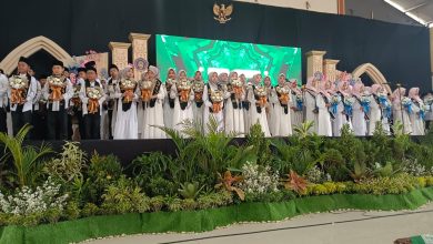 Para siswa peserta Haflah Khotmil dan Tahfidz Al-Quran SD Muhammadiyah Parakan Temanggung berdiri di atas panggung wisuda sambil membawa buket bunga.