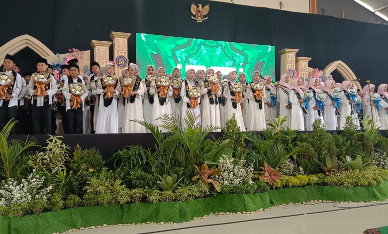 Para siswa peserta Haflah Khotmil dan Tahfidz Al-Quran SD Muhammadiyah Parakan Temanggung berdiri di atas panggung wisuda sambil membawa buket bunga.
