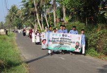 Siswa Perguruan Muhammadiyah Bayan membentangkan spanduk Pawai Menyambut Bulan Muharram 1448 H di jalan pedesaan Purworejo.