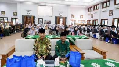 Suasana rapat koordinasi pengurus Muhammadiyah secara lesehan menggunakan laptop di dalam gedung serbaguna.