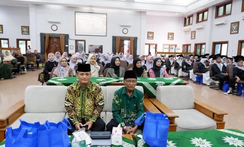 Suasana rapat koordinasi pengurus Muhammadiyah secara lesehan menggunakan laptop di dalam gedung serbaguna.