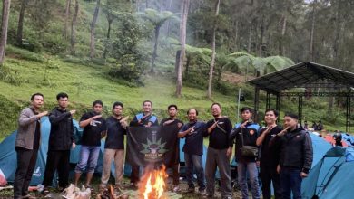Prosesi pemakaian baret merah oleh jajaran komandan dan sesepuh Muhammadiyah kepada para kader KOKAM baru yang berlutut dengan takzim.
