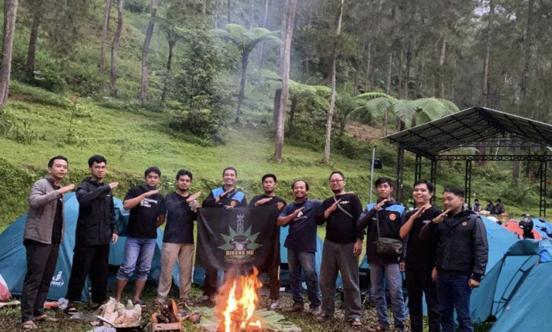 Prosesi pemakaian baret merah oleh jajaran komandan dan sesepuh Muhammadiyah kepada para kader KOKAM baru yang berlutut dengan takzim.