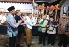 Penyerahan tokoh wayang kulit secara simbolis oleh pengurus LDK PWM Jawa Tengah kepada perwakilan dalam acara Safari Dakwah Kultural Muhammadiyah di Boyolali dengan latar belakang panggung gamelan.