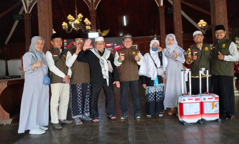 Foto bersama jajaran pengurus organisasi bersama jemaah haji kader Muhammadiyah di dalam gedung pendopo berarsitektur tradisional.