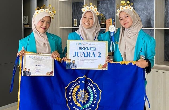 Tiga mahasiswa PG-PAUD UMS tersenyum memakai jas almamater biru sembari memegang sertifikat, medali, dan papan penghargaan Juara 2 EKKN 4 tahun 2026, di depannya terbentang bendera biru Universitas Muhammadiyah Surakarta.