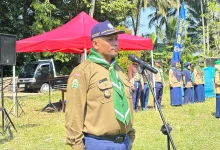 Ahmad Haryanto memberikan sambutan di depan mikrofon saat pembukaan kegiatan Kemah Hizbul Wathan SMP Mutual Kota Magelang di lapangan terbuka.