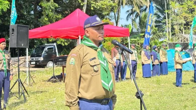 Ahmad Haryanto memberikan sambutan di depan mikrofon saat pembukaan kegiatan Kemah Hizbul Wathan SMP Mutual Kota Magelang di lapangan terbuka.
