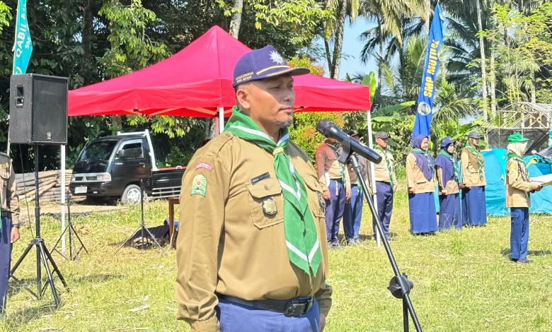 Ahmad Haryanto memberikan sambutan di depan mikrofon saat pembukaan kegiatan Kemah Hizbul Wathan SMP Mutual Kota Magelang di lapangan terbuka.