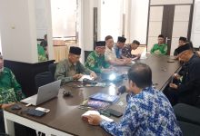 Rapat Koordinasi PRM Tanjung Banyumas menyambut Tahun Baru Islam 2026, para pengurus mengenakan batik hijau Muhammadiyah duduk mengitari meja rapat di Rumah Makan Sambel Bletok.
