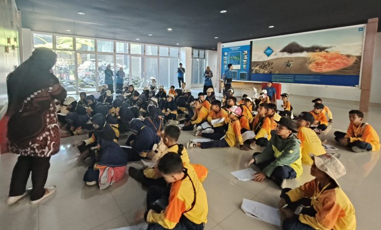 Siswa MIM Kauman Pekalongan duduk memperhatikan edukasi vulkanologi di dalam Museum Gunung Merapi saat agenda wisata hits jogja.