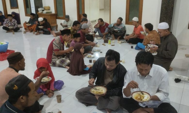 Jemaah Masjid Al Muttaqin Kedung Jepara sedang makan bersama duduk bersila di lantai dalam acara Jumat Berkah.