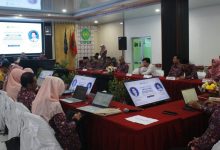 Suasana rapat Asesmen Lapangan Akreditasi LAMDIK di UMPWR, menampilkan peserta yang duduk di meja melingkar dengan laptop dan layar presentasi.