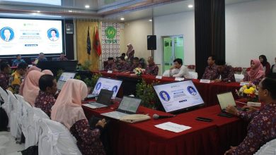 Suasana rapat Asesmen Lapangan Akreditasi LAMDIK di UMPWR, menampilkan peserta yang duduk di meja melingkar dengan laptop dan layar presentasi.