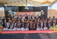 Sekelompok guru dan siswa berpose bersama di atas panggung dalam acara 'Pentas Ceria' sekolah.