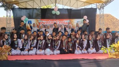 Sekelompok guru dan siswa berpose bersama di atas panggung dalam acara 'Pentas Ceria' sekolah.