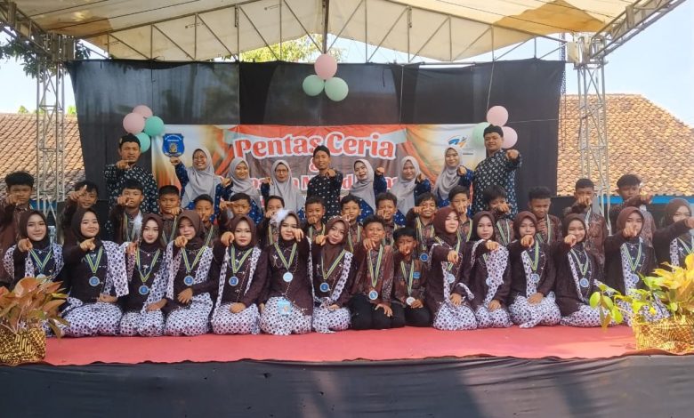 Sekelompok guru dan siswa berpose bersama di atas panggung dalam acara 'Pentas Ceria' sekolah.