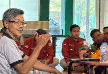 Suasana rapat koordinasi Lazismu dihadiri beberapa pria berseragam merah yang menyimak pemaparan pembicara berkaus abu-abu.