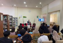 Seorang pemateri wanita menyampaikan presentasi metodologi pembelajaran di ruang perpustakaan Klinik Al-Qur'an.