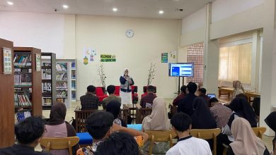 Seorang pemateri wanita menyampaikan presentasi metodologi pembelajaran di ruang perpustakaan Klinik Al-Qur'an.
