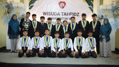 Para siswa wisudawan tahfidz MI Muhammadiyah Malebo Temanggung foto bersama di atas panggung mengenakan samir wisuda dan jas hitam.