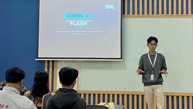 Muhammad Hasbi Assidiqi mahasiswa UMS lolos Google Student Ambassador 2026 sedang berdiri memberikan presentasi materi Gemini 3.5 Flash di depan layar proyektor ruang kelas.